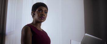 Movie still from “Mayhem” (2017), directed by Joe Lynch – A woman wearing a red dress with a white background; Close Up shot, Over the shoulder angle