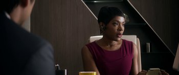 Movie still from “Mayhem” (2017), directed by Joe Lynch – A woman sitting at a table with a cup in front of her; Close Up shot, Over the shoulder angle