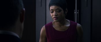 Movie still from “Mayhem” (2017), directed by Joe Lynch – A woman in a red dress is looking down; Close Up shot, Over the shoulder angle