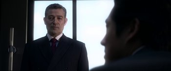 Movie still from “Mayhem” (2017), directed by Joe Lynch – A person wearing a suit and tie; Close Up shot, Over the shoulder angle