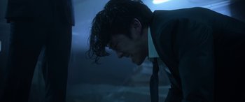 Movie still from “Mayhem” (2017), directed by Joe Lynch – A man in a suit and tie is smiling; Close Up shot, Low angle