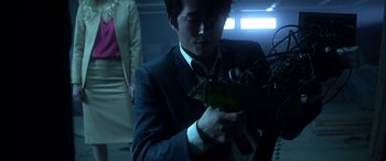 Movie still from “Mayhem” (2017), directed by Joe Lynch – A man in a business suit holding a bunch of wires; Close Up shot, Low angle