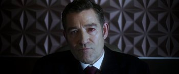 Movie still from “Mayhem” (2017), directed by Joe Lynch – A person wearing a suit and tie; Close Up shot, High angle