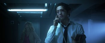 Movie still from “Mayhem” (2017), directed by Joe Lynch – A man talking on a phone while wearing a tie; Medium shot, Low angle