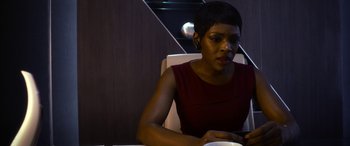 Movie still from “Mayhem” (2017), directed by Joe Lynch – A woman sitting at a table looking at her cell phone; Close Up shot, High angle