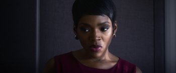 Movie still from “Mayhem” (2017), directed by Joe Lynch – A woman with short black hair wearing a red dress; Close Up shot, Low angle