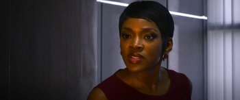 Movie still from “Mayhem” (2017), directed by Joe Lynch – A person with short black hair; Close Up shot, Over the shoulder angle