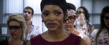 Movie still from “Mayhem” (2017), directed by Joe Lynch – A person with short black hair; Close Up shot, Over the shoulder angle