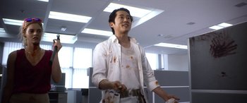 Movie still from “Mayhem” (2017), directed by Joe Lynch – A man in a white shirt is playing a video game in an office setting; Medium shot, Low angle