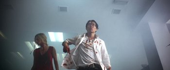Movie still from “Mayhem” (2017), directed by Joe Lynch – A man holding a bloody knife in a room; Medium shot, Low angle