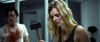 Movie still from “Mayhem” (2017), directed by Joe Lynch – A woman holding a hammer with blood all over her face; Close Up shot, Over the shoulder angle