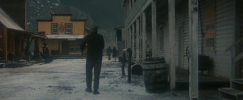 Movie still from “McCabe & Mrs. Miller” (1971), directed by Robert Altman – A man standing on the side of a road in the snow; Wide shot, High angle