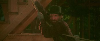 Movie still from “McCabe & Mrs. Miller” (1971), directed by Robert Altman – A man in a hat is pulling a rope; Medium shot, Low angle