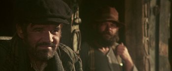 Movie still from “McCabe & Mrs. Miller” (1971), directed by Robert Altman – A man with a beard wearing a hat and a jacket; Close Up shot, Over the shoulder angle