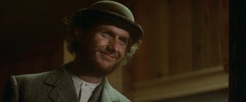 Movie still from “McCabe & Mrs. Miller” (1971), directed by Robert Altman – A person wearing a hat and a suit; Close Up shot, Low angle