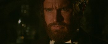 Movie still from “McCabe & Mrs. Miller” (1971), directed by Robert Altman – A person wearing a suit and tie; Close Up shot, Low angle