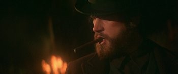 Movie still from “McCabe & Mrs. Miller” (1971), directed by Robert Altman – A man wearing a hat and smoking a cigar; Close Up shot, Over the shoulder angle