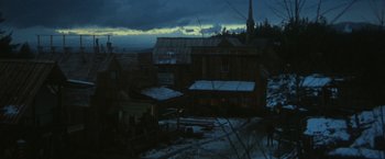 Movie still from “McCabe & Mrs. Miller” (1971), directed by Robert Altman – A view of a town at night with a cloudy sky in the background; Extreme Wide shot, High angle