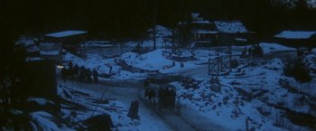 Movie still from “McCabe & Mrs. Miller” (1971), directed by Robert Altman – A horse drawn carriage traveling down a snow covered road; Extreme Wide shot, High angle