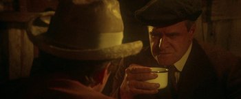 Movie still from “McCabe & Mrs. Miller” (1971), directed by Robert Altman – An old man drinking a cup of coffee; Close Up shot, Over the shoulder angle