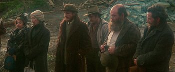 Movie still from “McCabe & Mrs. Miller” (1971), directed by Robert Altman – A group of men standing next to each other on a field; Medium shot, Low angle