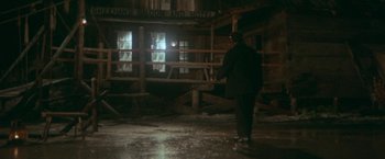 Movie still from “McCabe & Mrs. Miller” (1971), directed by Robert Altman – A man standing in the middle of an abandoned building; Wide shot, High angle