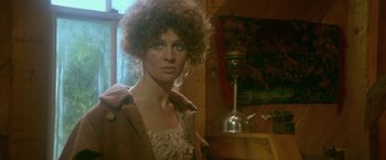 Movie still from “McCabe & Mrs. Miller” (1971), directed by Robert Altman – A woman in a brown coat standing next to a lamp; Close Up shot, Low angle