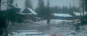 Movie still from “McCabe & Mrs. Miller” (1971), directed by Robert Altman – A person walking across a bridge in the snow; Extreme Wide shot, High angle