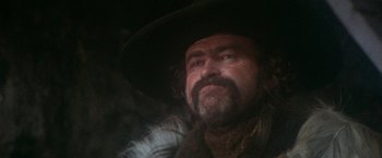 Movie still from “McCabe & Mrs. Miller” (1971), directed by Robert Altman – A person wearing a hat and a beard; Close Up shot, Low angle