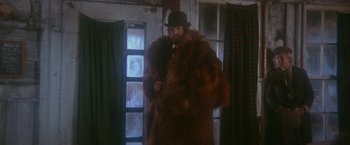 Movie still from “McCabe & Mrs. Miller” (1971), directed by Robert Altman – A man in a fur coat and a hat; Medium shot, Low angle