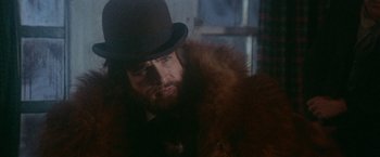 Movie still from “McCabe & Mrs. Miller” (1971), directed by Robert Altman – A man in a hat and a fur coat looking to his left; Close Up shot, Over the shoulder angle