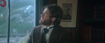 Movie still from “McCabe & Mrs. Miller” (1971), directed by Robert Altman – A man in a suit and tie looking out of a window; Close Up shot, Low angle