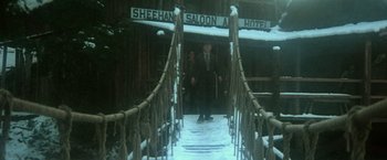 Movie still from “McCabe & Mrs. Miller” (1971), directed by Robert Altman – A man and a woman walking across a bridge; Wide shot, Low angle