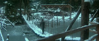 Movie still from “McCabe & Mrs. Miller” (1971), directed by Robert Altman – A man walking across a snow covered bridge; Extreme Wide shot, High angle