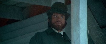 Movie still from “McCabe & Mrs. Miller” (1971), directed by Robert Altman – A man with a beard wearing a hat and a coat; Close Up shot, Low angle