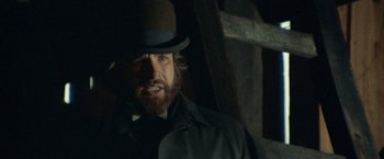 Movie still from “McCabe & Mrs. Miller” (1971), directed by Robert Altman – A man with a beard wearing a top hat; Close Up shot, Low angle