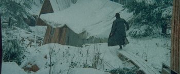 Movie still from “McCabe & Mrs. Miller” (1971), directed by Robert Altman – A man in a trench coat walking in the snow; Wide shot, High angle