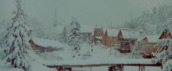 Movie still from “McCabe & Mrs. Miller” (1971), directed by Robert Altman – A view of a snow - covered town with a church in the background; Extreme Wide shot, High angle