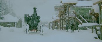 Movie still from “McCabe & Mrs. Miller” (1971), directed by Robert Altman – A train on the tracks in the snow near a building; Extreme Wide shot, High angle