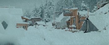 Movie still from “McCabe & Mrs. Miller” (1971), directed by Robert Altman – A snowy scene with a building and trees in the background; Extreme Wide shot, High angle