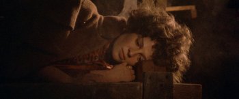 Movie still from “McCabe & Mrs. Miller” (1971), directed by Robert Altman – A woman laying on the ground with her head resting on her hand; Close Up shot, Overhead angle