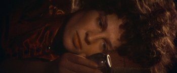 Movie still from “McCabe & Mrs. Miller” (1971), directed by Robert Altman – A man holding a cell phone up to his ear; Close Up shot, Overhead angle