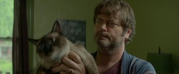 Movie still from “Me and Earl and the Dying Girl” (2015), directed by Alfonso Gomez-Rejon – A man holding a siamese cat in his hands; Close Up shot, Over the shoulder angle