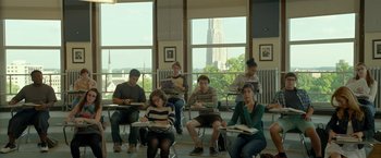Movie still from “Me and Earl and the Dying Girl” (2015), directed by Alfonso Gomez-Rejon – A group of people sitting at a desk in front of a window; Wide shot, High angle