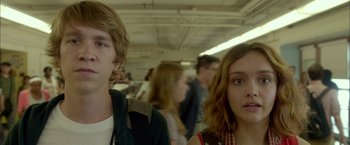 Movie still from “Me and Earl and the Dying Girl” (2015), directed by Alfonso Gomez-Rejon – A man and a woman standing next to each other in a room; Close Up shot, Low angle