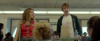 Movie still from “Me and Earl and the Dying Girl” (2015), directed by Alfonso Gomez-Rejon – A group of people standing around a table; Medium shot, Over the shoulder angle