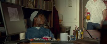 Movie still from “Me and Earl and the Dying Girl” (2015), directed by Alfonso Gomez-Rejon – A man sitting in front of a computer desk; Medium shot, Over the shoulder angle