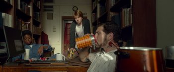 Movie still from “Me and Earl and the Dying Girl” (2015), directed by Alfonso Gomez-Rejon – A man is drinking from a cup while another man watches; Medium shot, Low angle