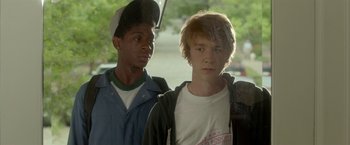 Movie still from “Me and Earl and the Dying Girl” (2015), directed by Alfonso Gomez-Rejon – Two young men standing next to each other in front of a car window; Close Up shot, Over the shoulder angle