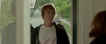 Movie still from “Me and Earl and the Dying Girl” (2015), directed by Alfonso Gomez-Rejon – A young man standing in front of a street; Medium shot, Over the shoulder angle